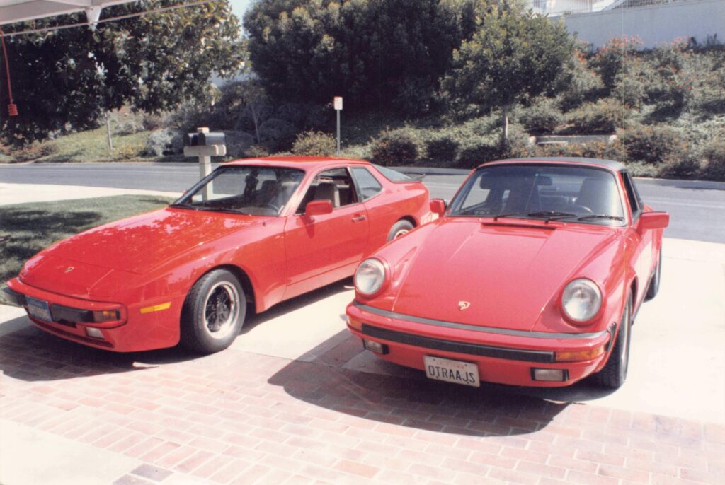 My father’s red Porsche 944 and his red 911 Carrera Targa, parked side by side in the driveway.