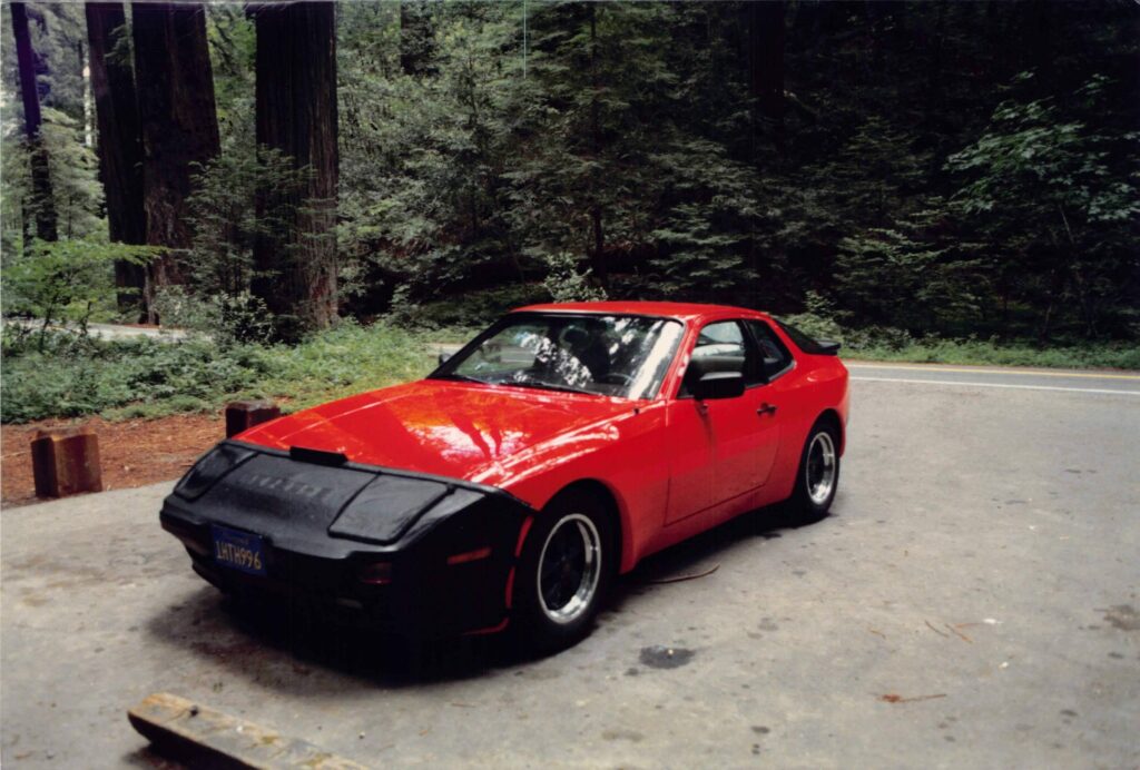 My father’s red Porsche 944 parked on a road through the redwoods.